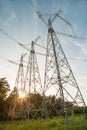 View of the masts of the power line against the background of blue sky, white clouds, beautiful green forest Royalty Free Stock Photo