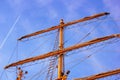 View of the masts and rigging of a sailing ship close-up against the background of sky with a flying airplane Royalty Free Stock Photo