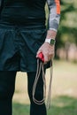 View of mature sportsman in fitness tracker holding jump rope