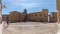 View at the medieval building at the San Pablo convent, on Plaza de las Veletas, tourist people strolling on street, medieval