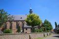 View on medieval church Sint Nicolaaskerk in small dutch village against blue summer sky