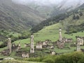View of the medieval Targim tower complex in the Caucasus mountains surrounded by greenery. The Caucasus Mountains on a Royalty Free Stock Photo