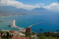 View on a Mediterranean sea coastline in Turkish city of Alanya with foggy mountains under cumulus clouds on the horizon Royalty Free Stock Photo