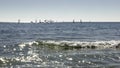 View of the Mediterranean Sea, waves. In the background are ships and sailboats. sunny day. View of the Mediterranean