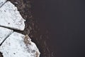 View of melting ice floes in muddy river water with garbage in spring Royalty Free Stock Photo