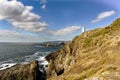 View of Mera lighthouse on a cliff on the atlantic coast of Spain in La CoruÃÂ±a. Sky with clouds and sun facing Royalty Free Stock Photo