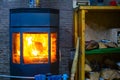 View of a metal furnace with tempered refractory glass, in which a bright flame of fire burns Royalty Free Stock Photo