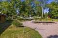 View of metal outdoor clothes dryer on backyard on green trees background. Royalty Free Stock Photo