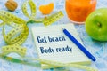 meter to measure waist size, healthy, diet food. Notebook with the motivational slogan `Get beach-body ready`. The concept of spr