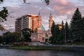 View on Minarets of Sunni Mukhtarov Mosque lit with warm sunset rays in front of pink gray clouds of summer evening sky