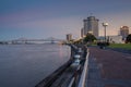 View of the Mississippi river from the city of New Orleans riverfront, with the Great New Orleans Bridge on the background in New