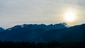 Beautiful view on the mountains from the top through the clouds. Jagged blue silhouettes mountain range.