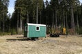 View on a mobile logger hut standing in the forest surrounded with tall trees in summer