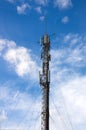 View of a mobile phone antenna from the ground with clouds and glades in the blue sky Royalty Free Stock Photo