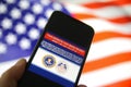 View on mobile phone screen with FBI notification this website has been seized, blurred us flag background