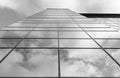 View of a modern glass skyscraper. A reflection of the cloudy sky in a glass skyscraper. Black and white photo Royalty Free Stock Photo