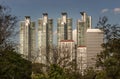 View of Modern high buildings among green trees space in nature against blue sky with clouds at afternoon Royalty Free Stock Photo