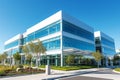 View of a modern office block with panoramic glazing against a blue sky. Adjacent territory with decorative landscaping Royalty Free Stock Photo