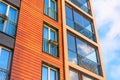 View of a modern residential brown building with balconies and windows, fences with boxes for flowers Royalty Free Stock Photo