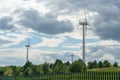 view of a modern windmill against a blue sky. The white blades of the wind turbine close up. Renewable energy source. Production