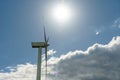 view of a modern windmill against a blue sky. The white blades of the wind turbine close up. Renewable energy source. Production