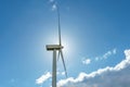 view of a modern windmill against a blue sky. The white blades of the wind turbine close up. Renewable energy source. Production