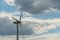 view of a modern windmill against a blue sky. The white blades of the wind turbine close up. Renewable energy source. Production