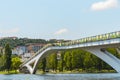 A view of the Mondego River and Coimbra City under a clear sky, with trees, pedestrian bridge, and buildings Royalty Free Stock Photo