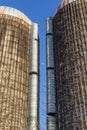 View of the moon between two tall grain silos with vines, blue sky
