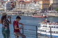 View of a mother and son looking and taking pictures at the Douro river and Porto downtown