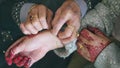 View of a mother tying a gold bracelet to her daughter during wedding day