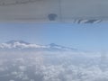 A view of Mount Kilimanjaro above the clouds seen from an aircraft window