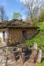 View of a mountain cabin with firewood on the wall and some wooden benches with chairs made of tree trunks Royalty Free Stock Photo