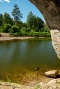 View from mountain cave at nature river water. View of the river, lake and beautiful shore with green trees Royalty Free Stock Photo