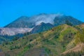 View of mountain ridges and sloping hills with trees under a clear blue sky