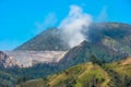 View of mountain ridges and sloping hills with trees under a clear blue sky