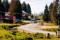 View of mountain road thorugh houses and trees in Bihor, Romania, 2023