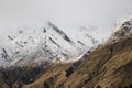 View on mountain scene of snowcapped mountains cover in fog during sunrise