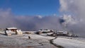 View of mountain station of a cableway in ski resort in Golm with snow covered meadows, snow cannon and rising clouds.
