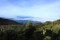View From Mountain Summit Over Clouds and Greenery Royalty Free Stock Photo