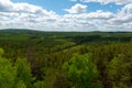 View from the mountain to the forest. White clouds on a blue sky. Royalty Free Stock Photo