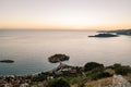 View from the mountain to the island of Sveti Stefan against the background of an orange sunset sky. Montenegro Royalty Free Stock Photo