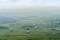 View from the mountain to the Russian village with a church and fields through a foggy haze Royalty Free Stock Photo