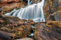 View of the mountain waterfall, streams of water over stones and driftwood, autumn leaves Royalty Free Stock Photo