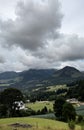 A view of a mountainous landscape under a cloudy sky with mountains in the distance Royalty Free Stock Photo