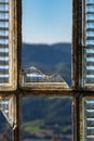 View of the mountains through the broken window in abandoned building Royalty Free Stock Photo