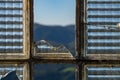 View of the mountains through the broken window in abandoned building Royalty Free Stock Photo