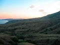 View of the mountains and hills descending to the calm sea after sunset