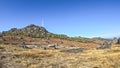 View of a mountains scene, with wind turbine, vegetation and granite stones and four-wheel drive vehicle moving on the scene