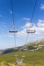 View on mountains in summer with ski lift on blue sky background Royalty Free Stock Photo